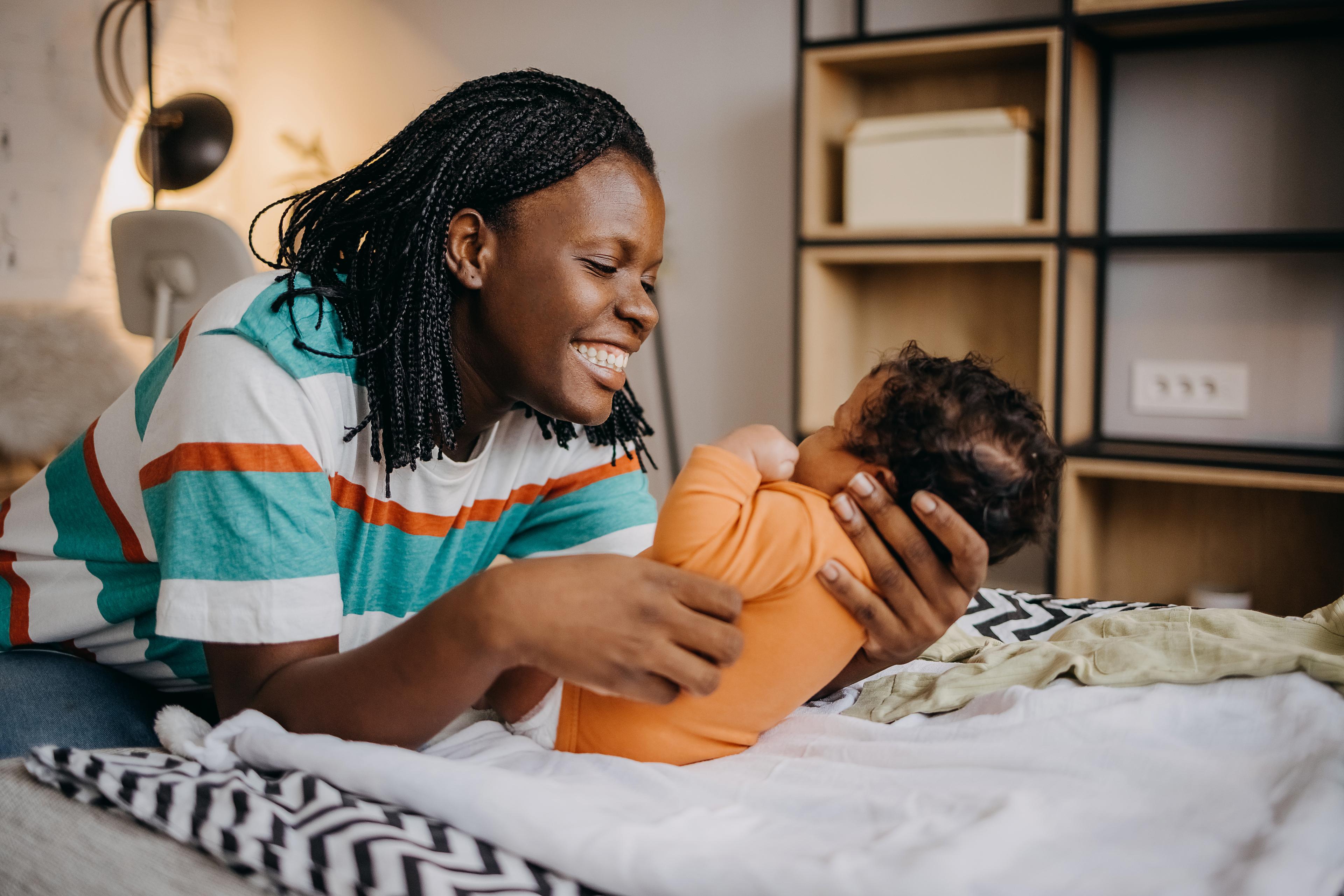 Pregnant woman playing with her toddler at home.
