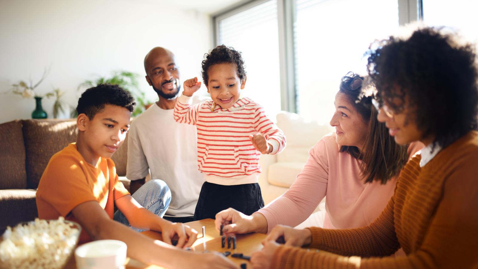 Happy family playing domino at home