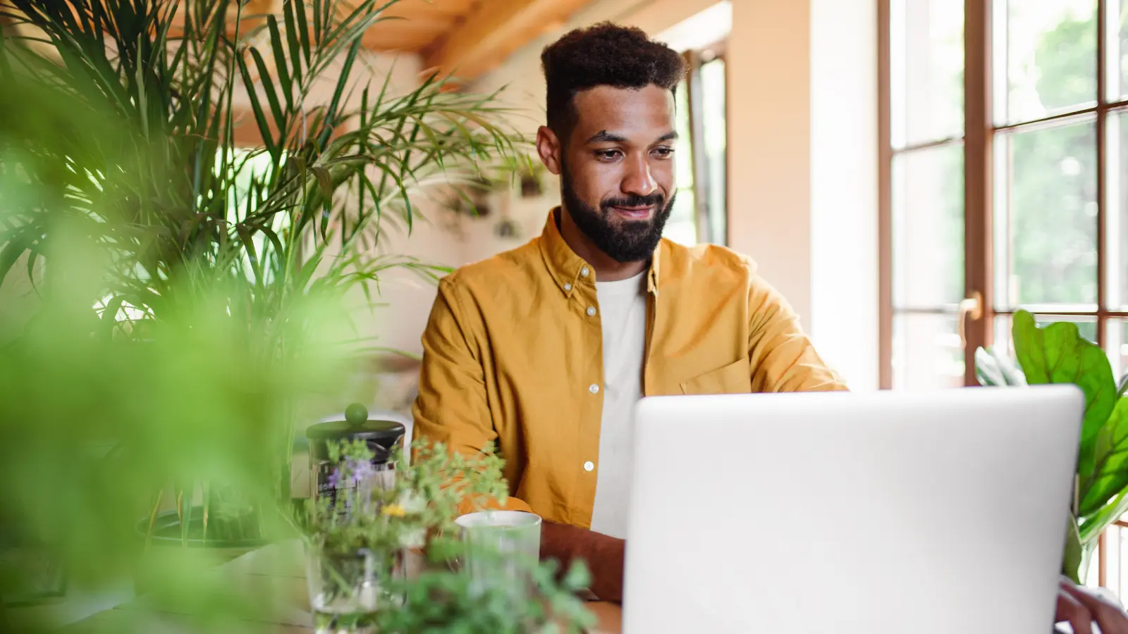 young man with laptop and coffee working indoors image young man with laptop and coffee working indoors