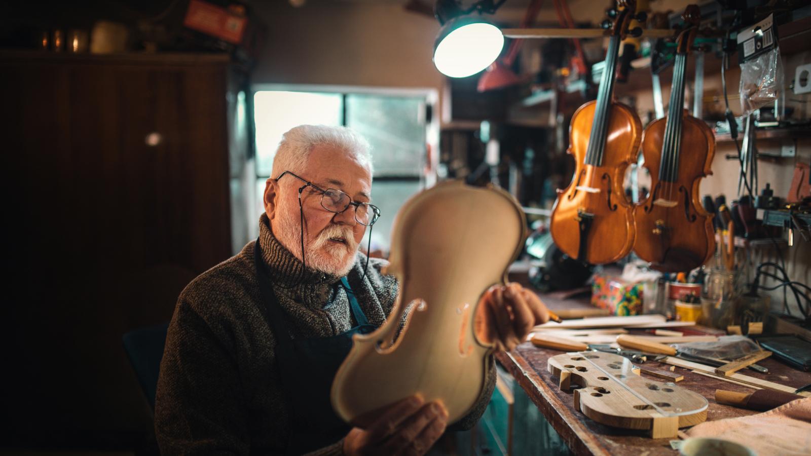 Senior craftsman making the violin