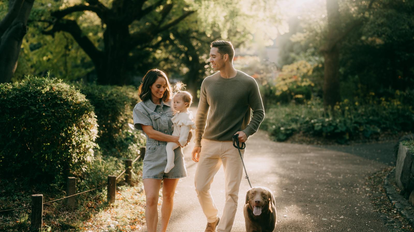 Happy family walking with their dog-in a park