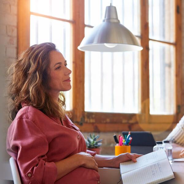 Pregnant businesswoman with colleagues in their office.
