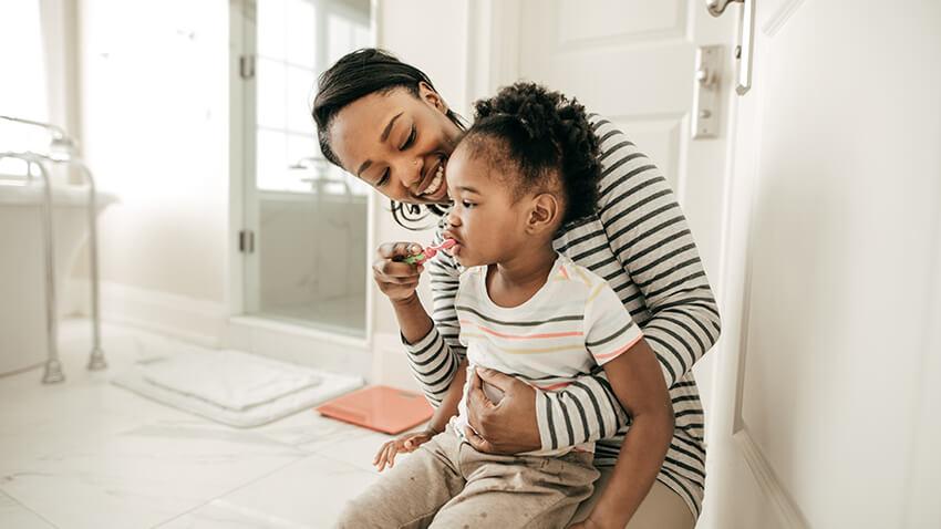 Mother brushing her todder's teeth