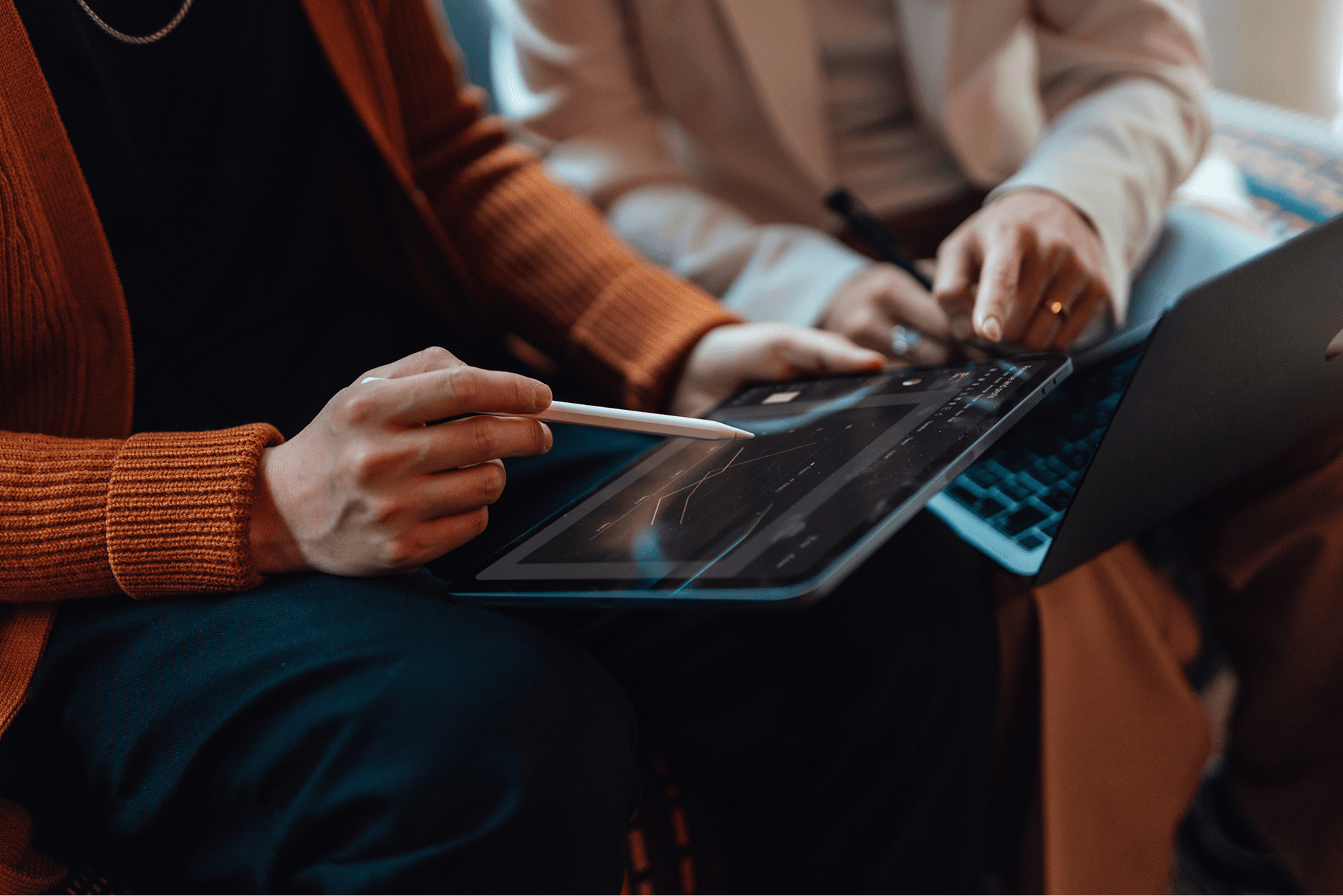 A person holds a stylus over a tablet screen.