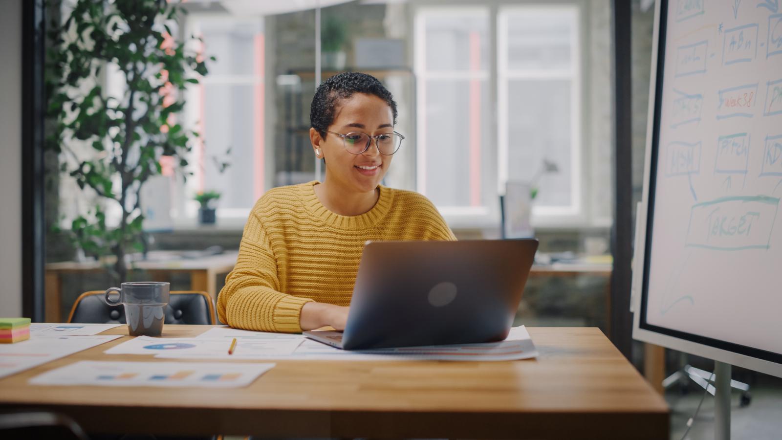 Marketing specialist in glasses working on laptop