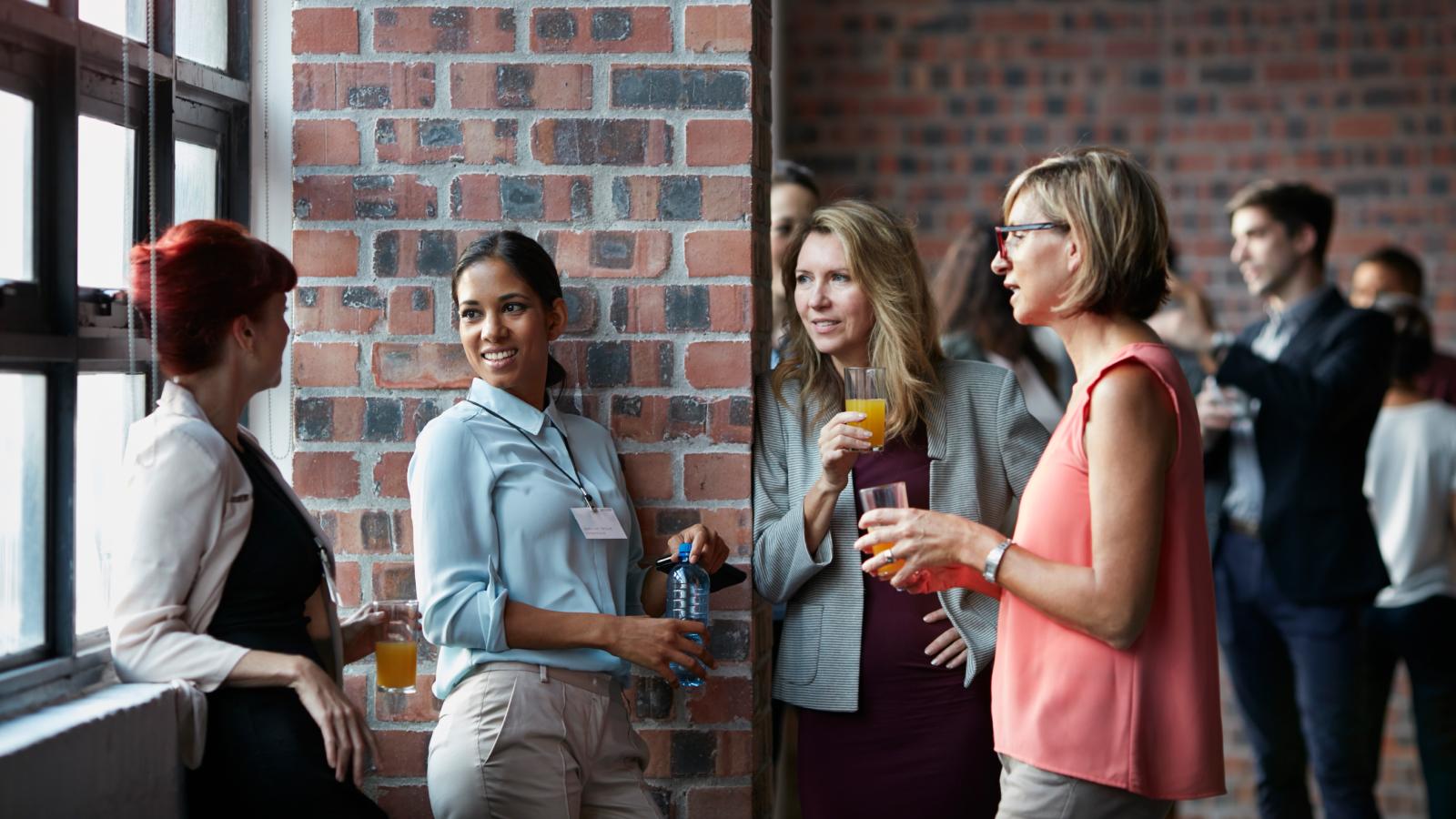 Businesspeople socializing by window of auditorium