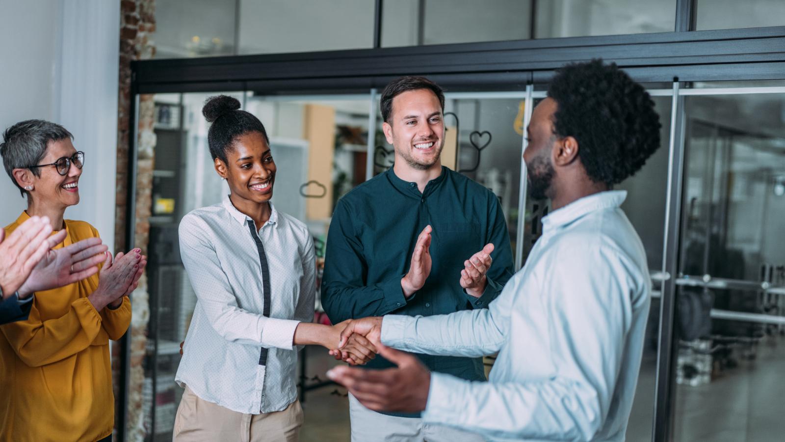 Team members shaking hands in office