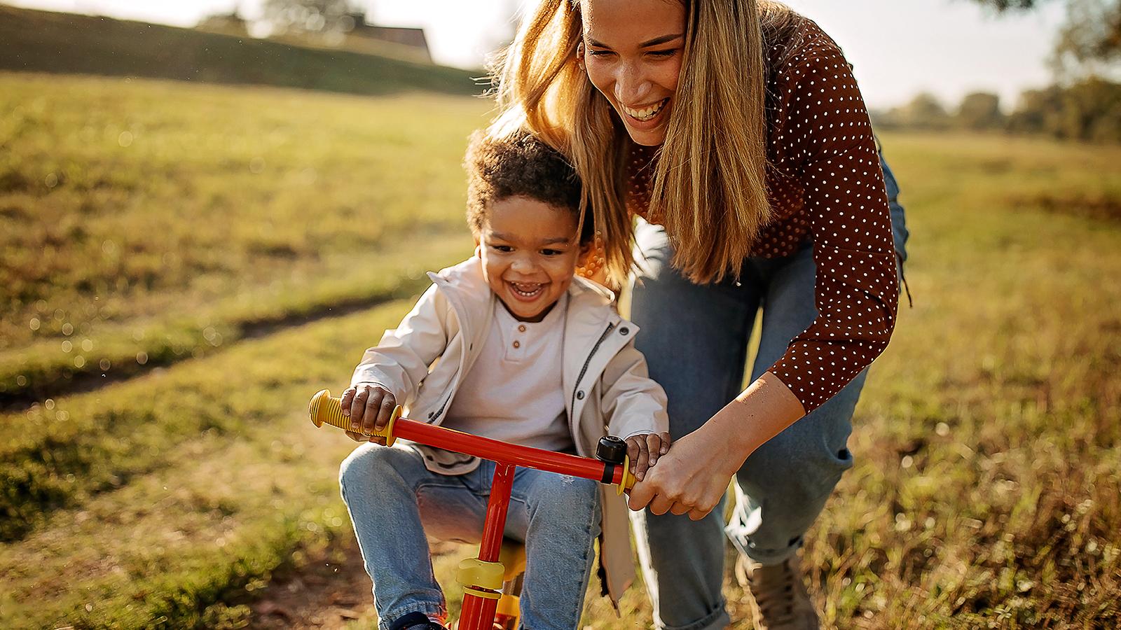 A mother teaching her son how to ride a bike