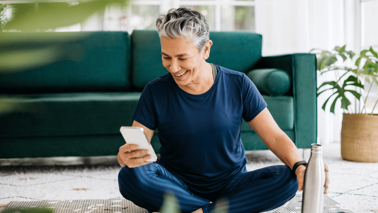 Old woman using smartphone during yoga break