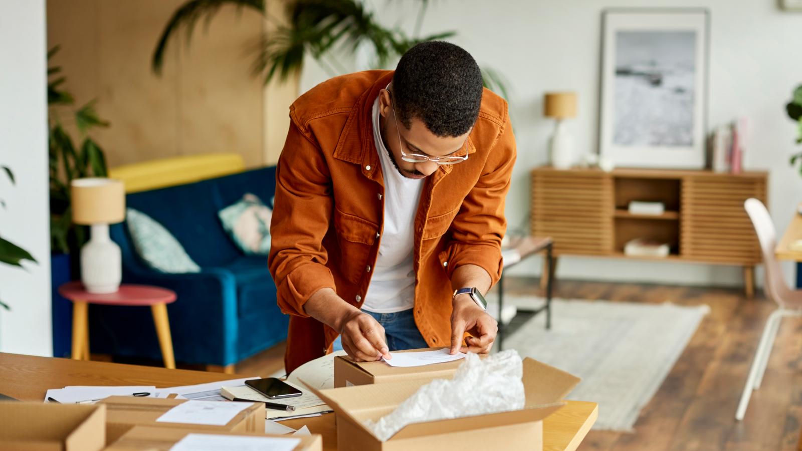Man labeling boxes at table