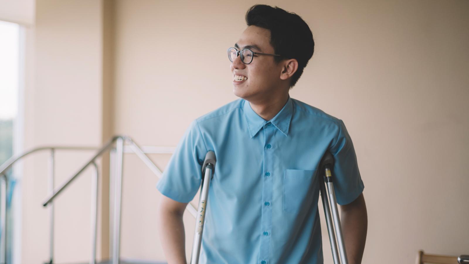 Chinese man smiling on crutches