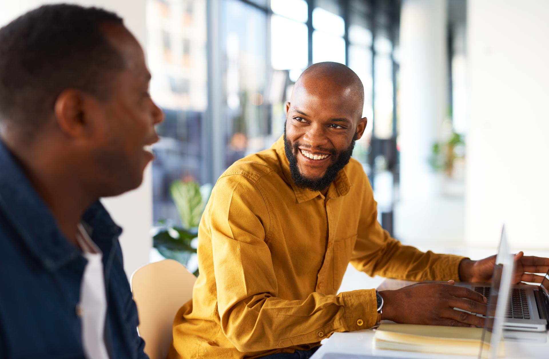 Two coworkers smiling and talking to each other. Two coworkers smiling and talking to each other.