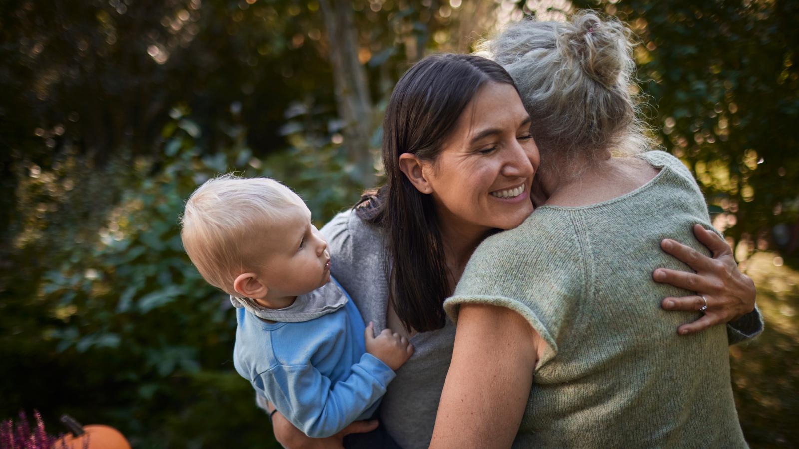 Woman with baby hugging mother