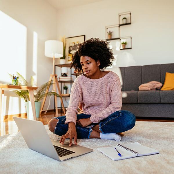 African-american millennial woman looking on her laptop.