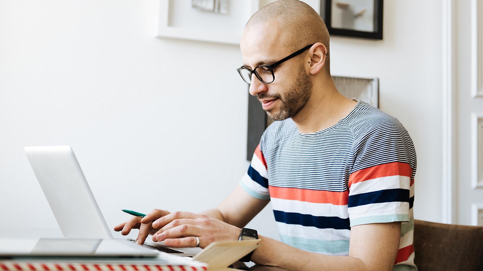 Man typing on his laptop at home