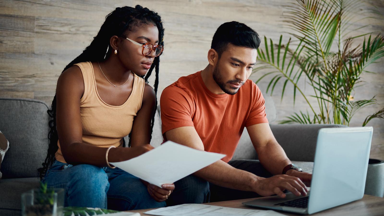 Couple using laptop and checking finances