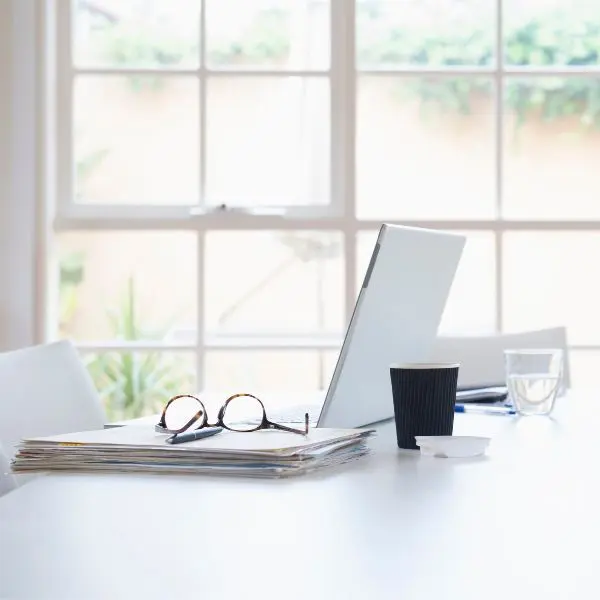 Laptop on a table near a window.