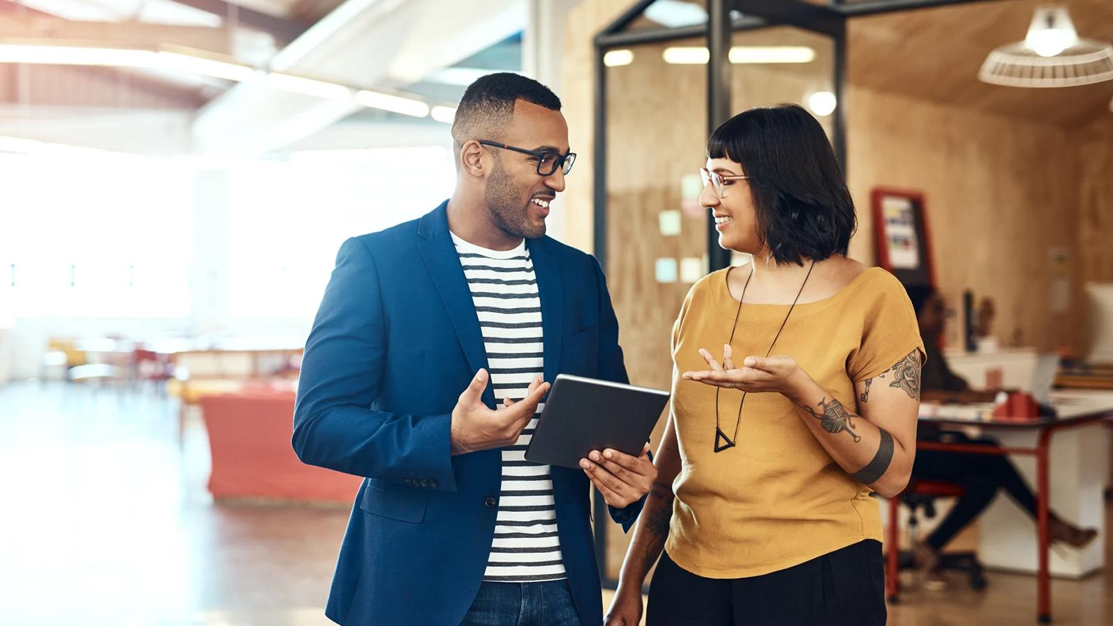 Two colleagues talking together in an office.