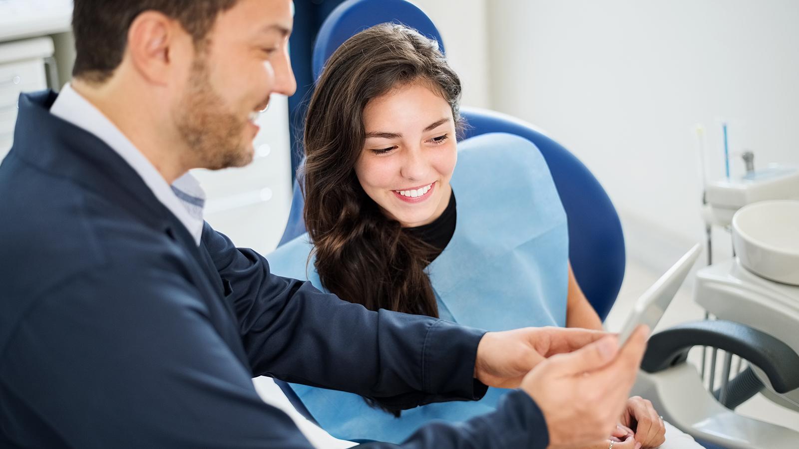 Dentist showing a patient images on a tablet