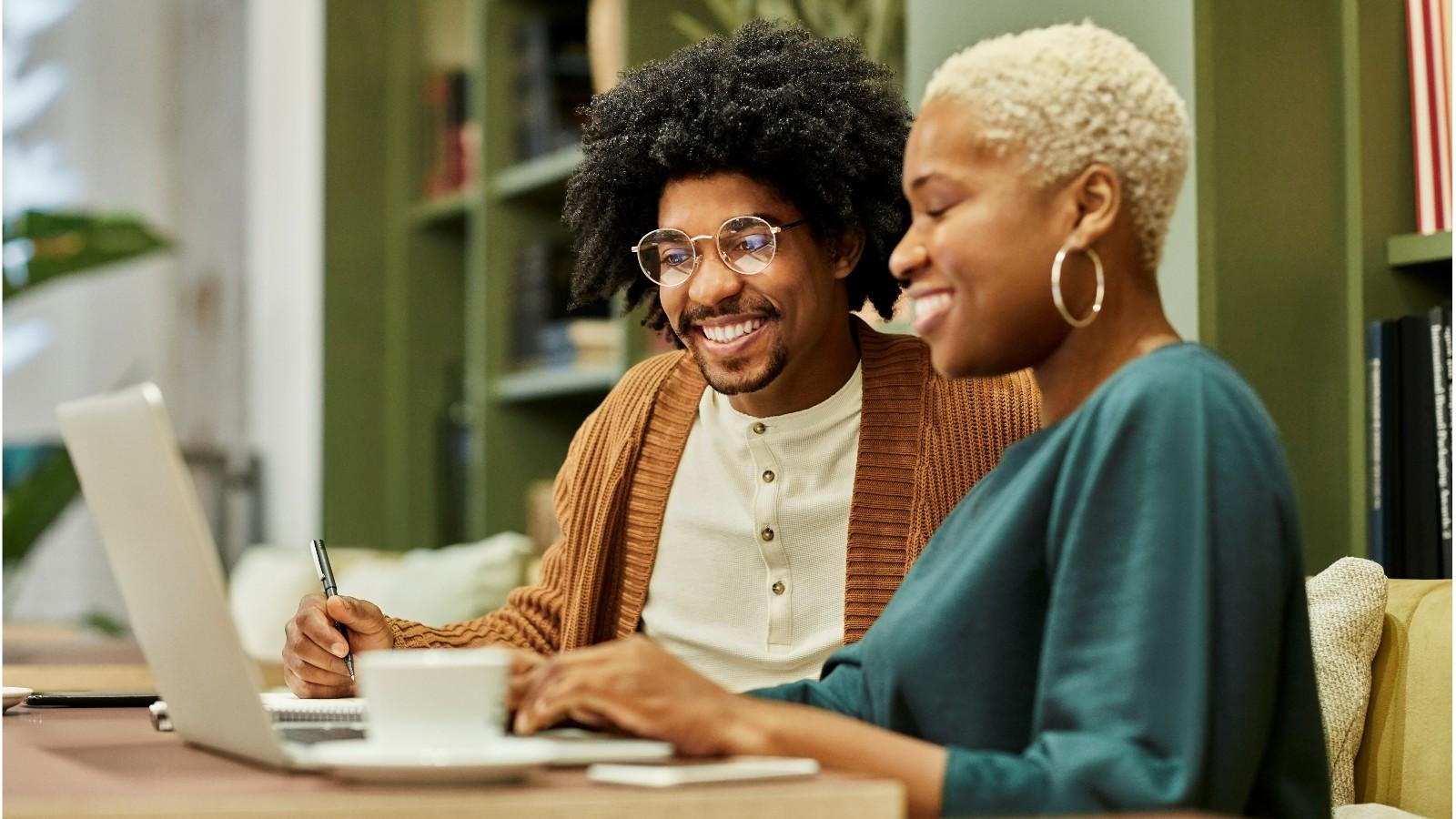 two people looking at the laptop and smiling