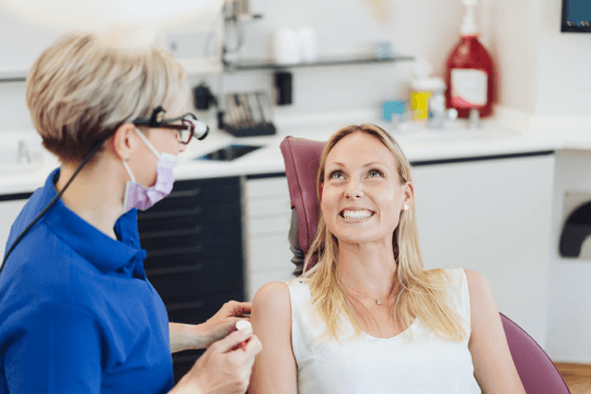Dentist with an adult female patient during a check up. Dentist with an adult female patient during a check up.