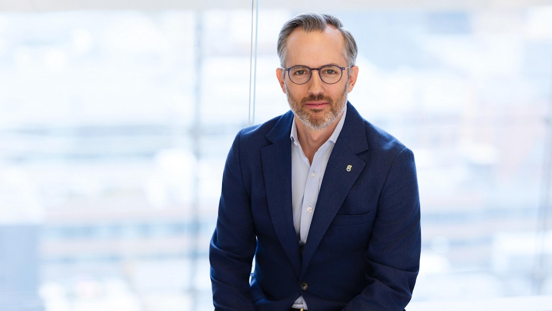 AR24 - Kevin img A professional headshot of a CFO wearing eyeglasses and a suit.
