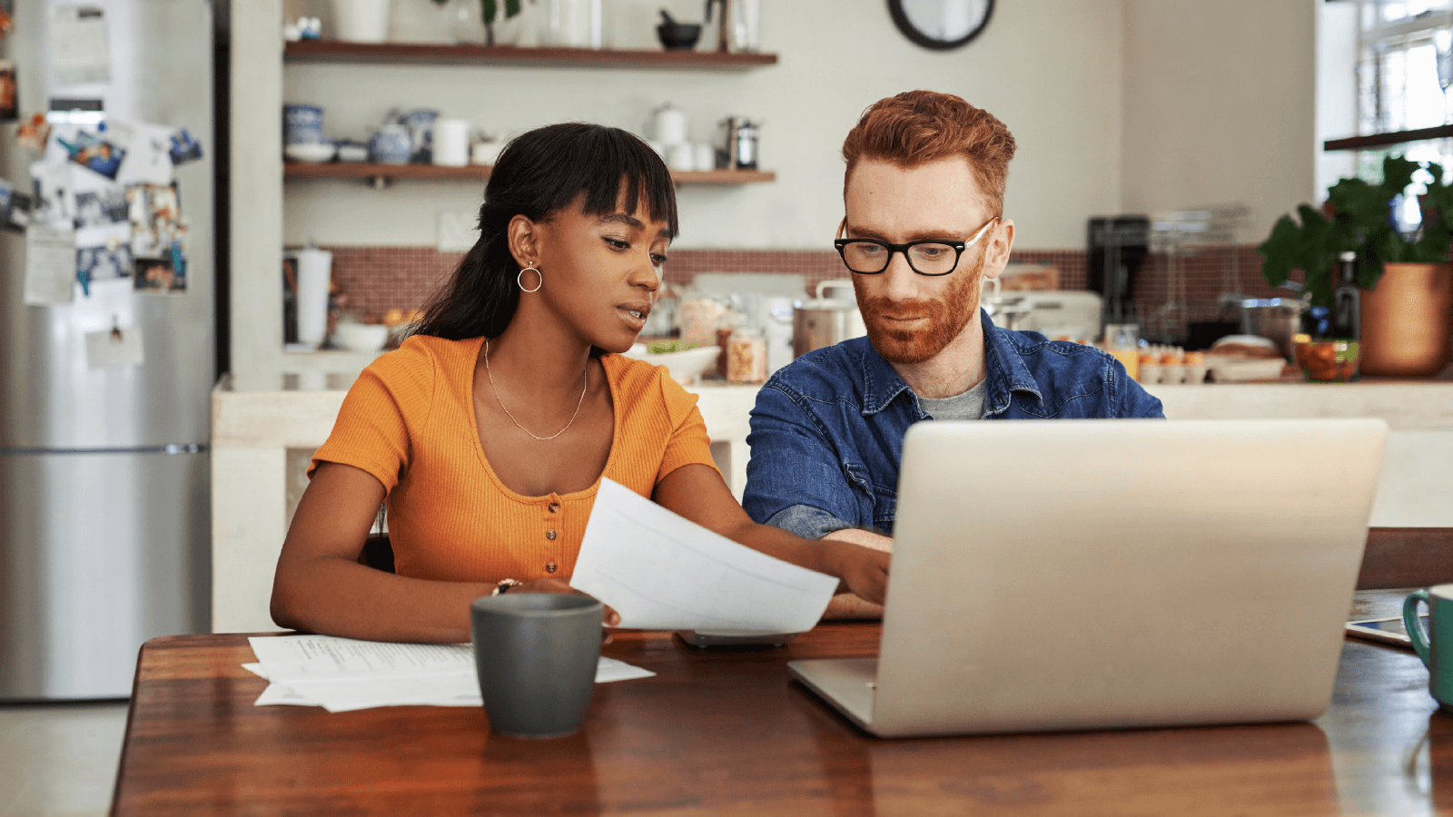 Wife and husband reviewing finances together at the kitchen table