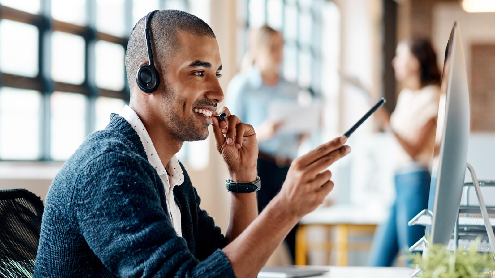 Man wearing a headset while working on his computer