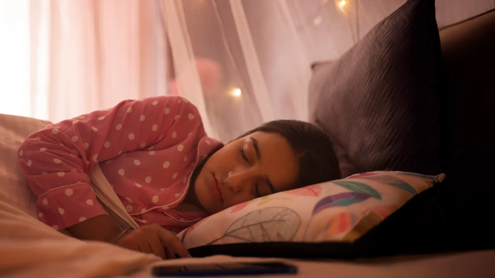 Teenage girl sleeping on bed