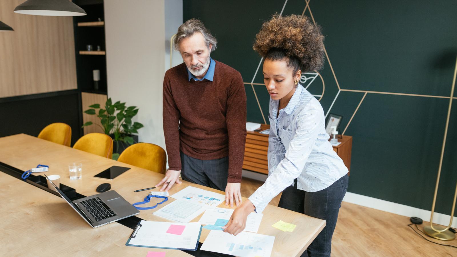 Senior advisor and young multiracial employee working in office