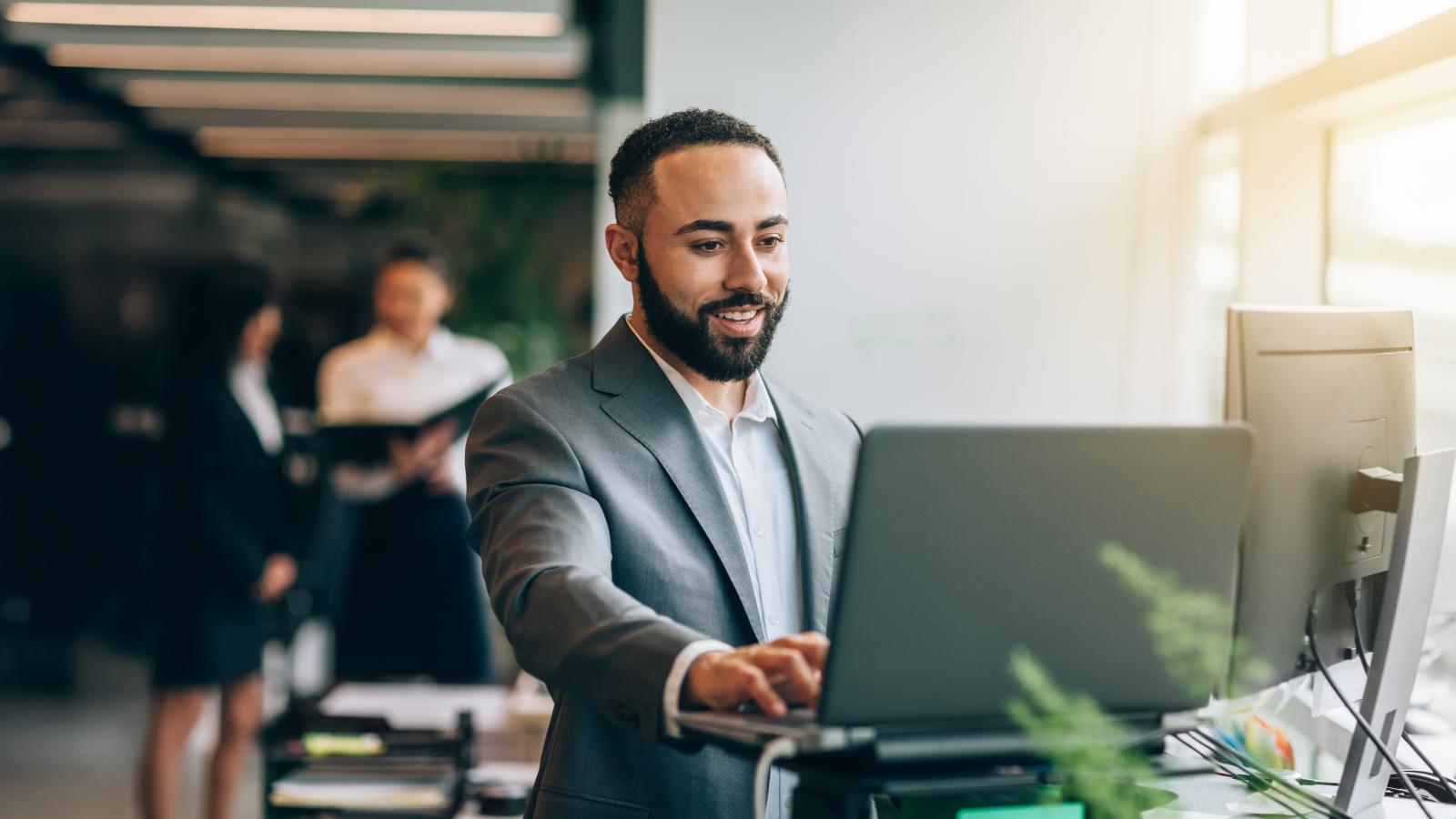 Businessman with standing desk with laptop