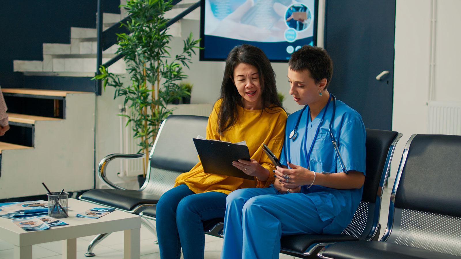 Woman examines papers with doctor