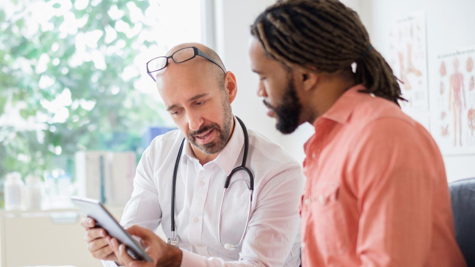 Doctor giving consultation to patient using digital tablet