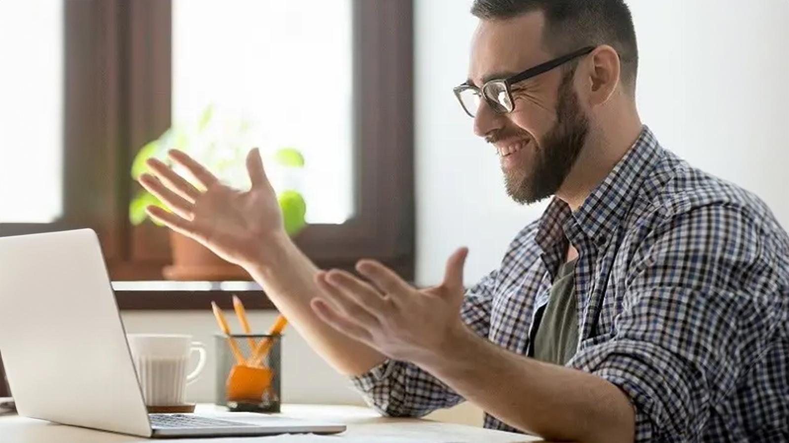 man smiles at his laptop Man smiles at his laptop.