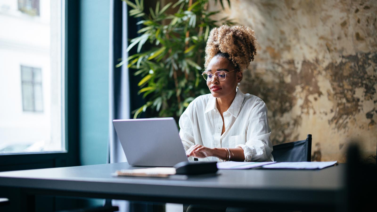 serious-woman-in-office-researching-on-laptop