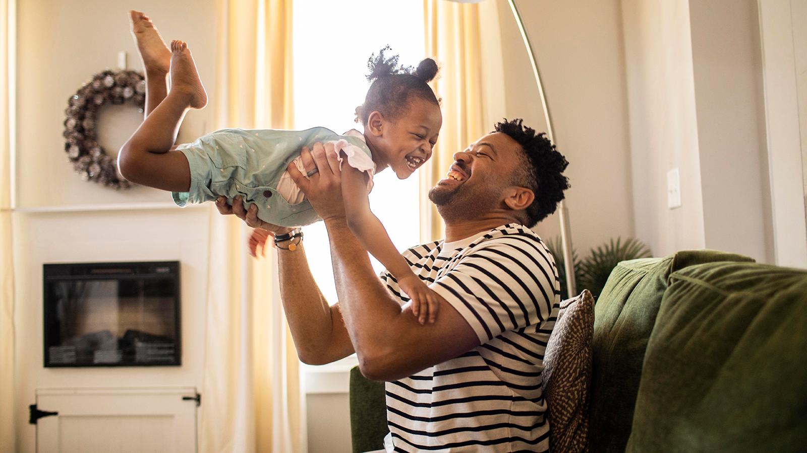 father lifting daughter having fun