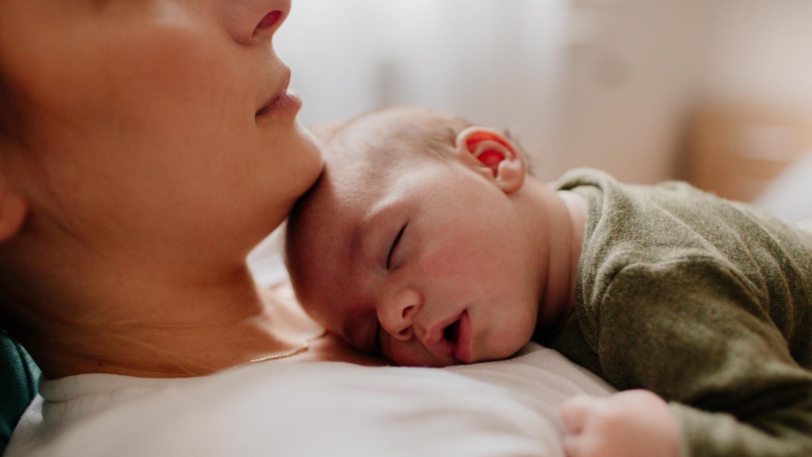 Mother putting her baby to sleep
