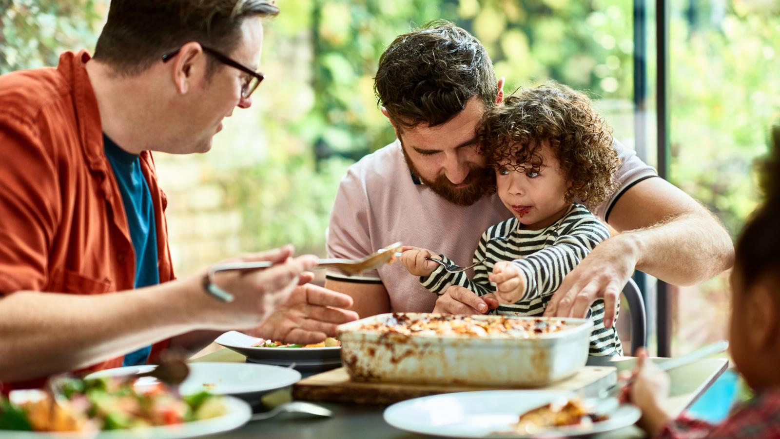 Men feeding toddler