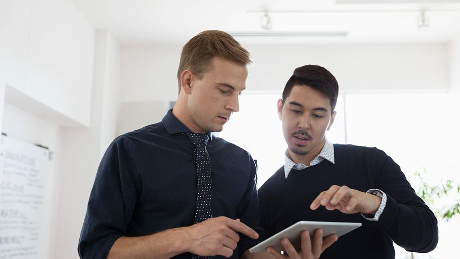 Two employees looking at a tablet together