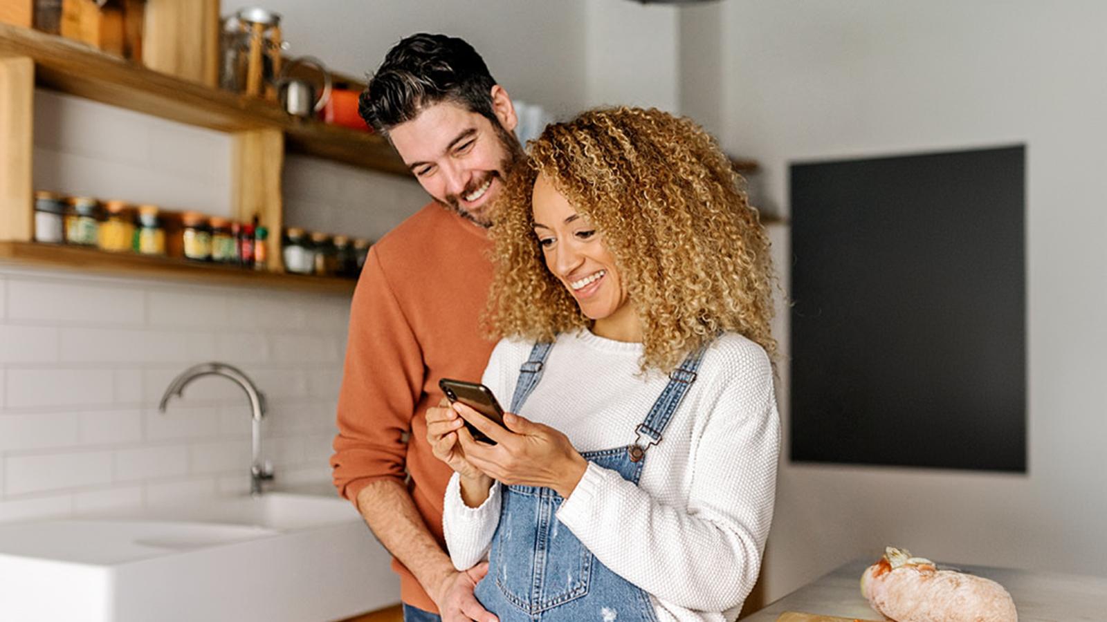 Smiling couple looking a phone together Smiling couple looking a phone together