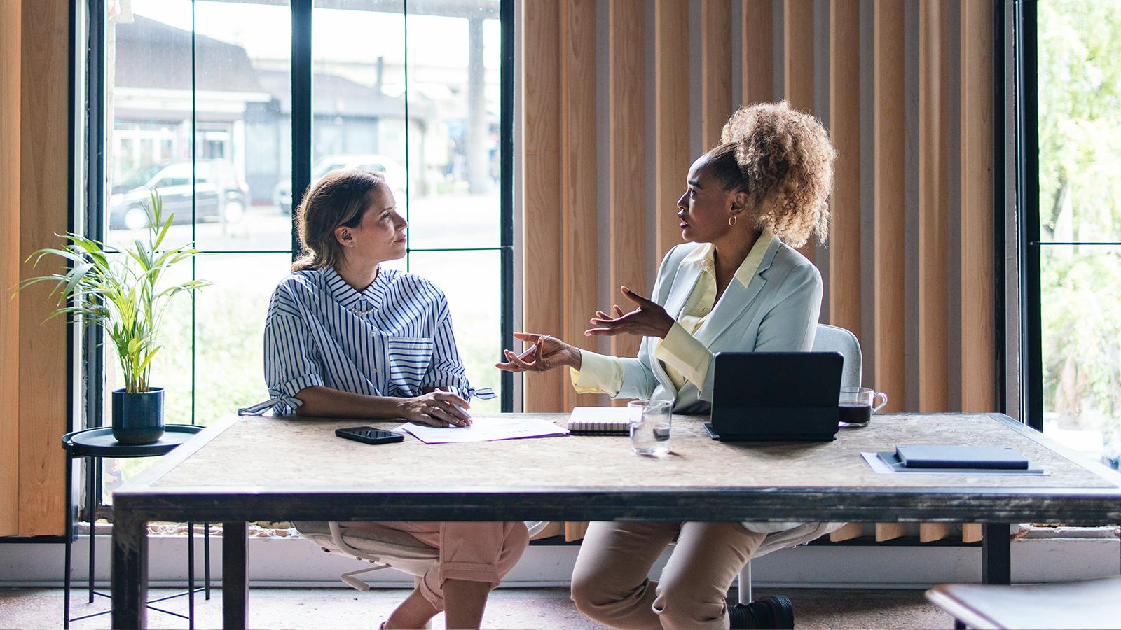 2 women at work speaking to each other