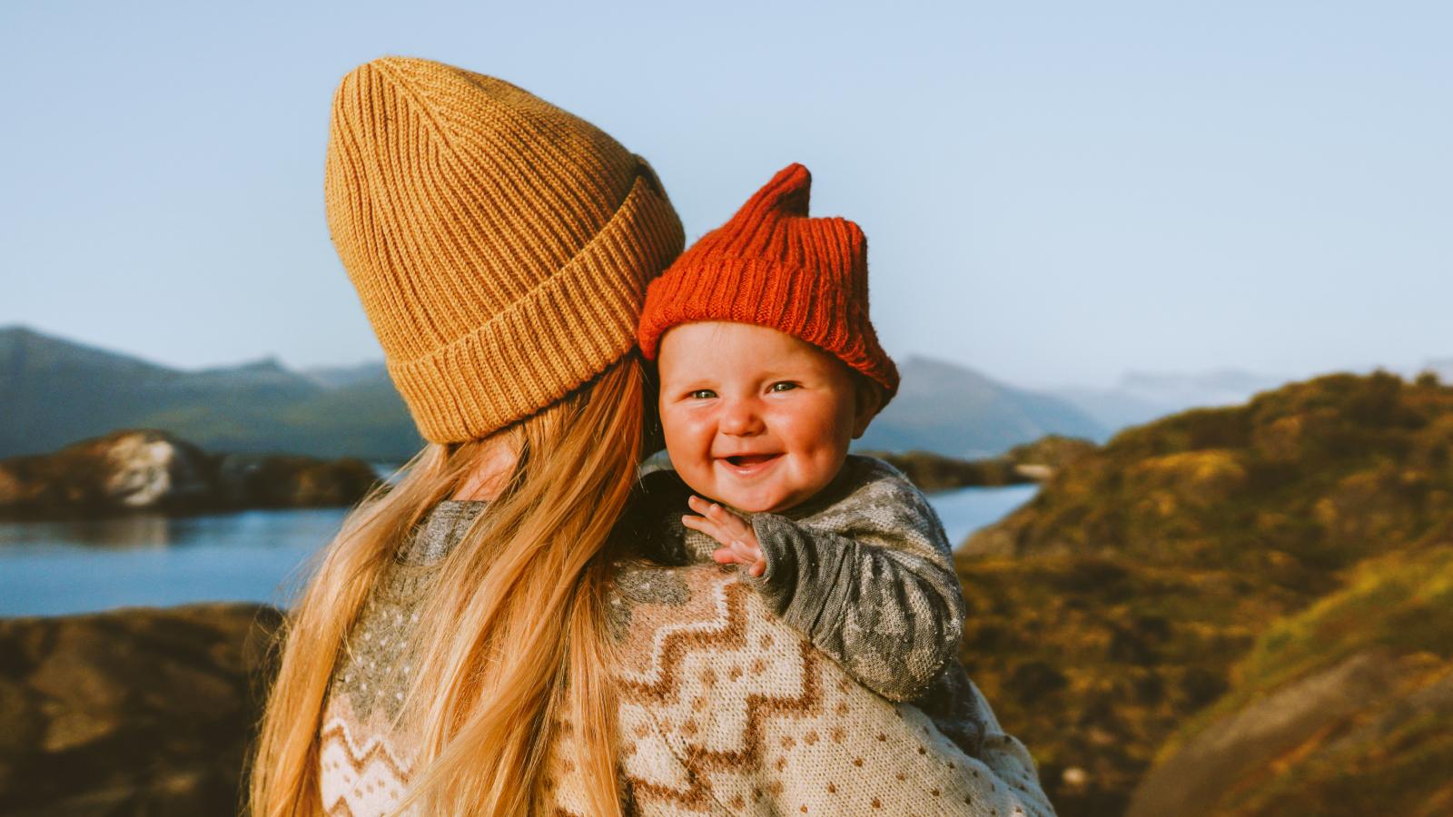 Mother holding smiling baby outside. Mother holding smiling baby outside.