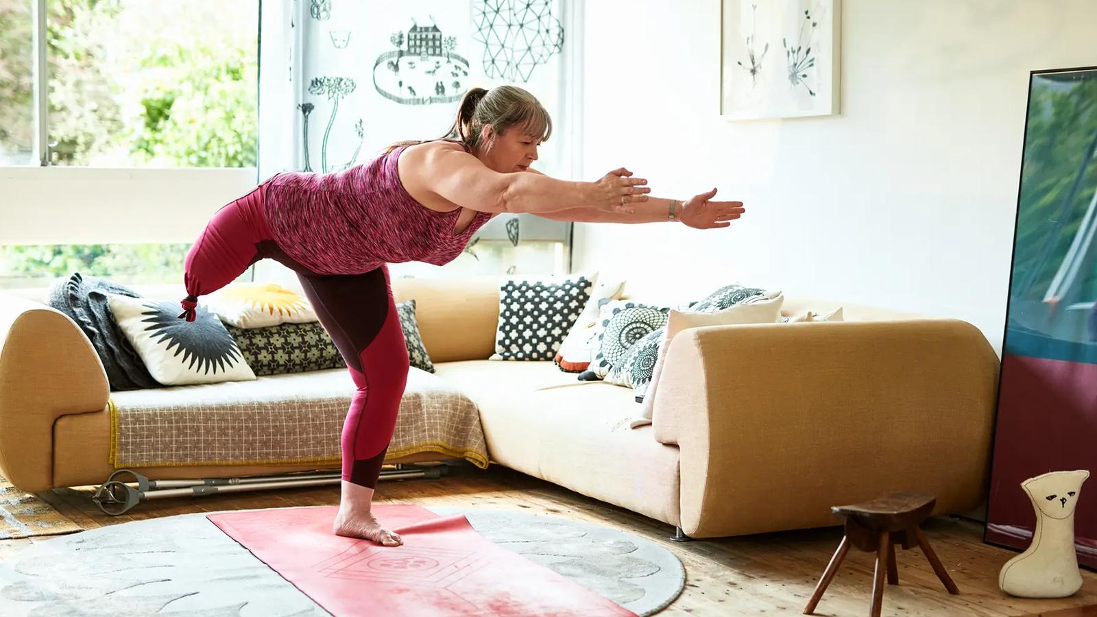 Woman with an amputated leg stretching at home. Woman with an amputated leg stretching at home.