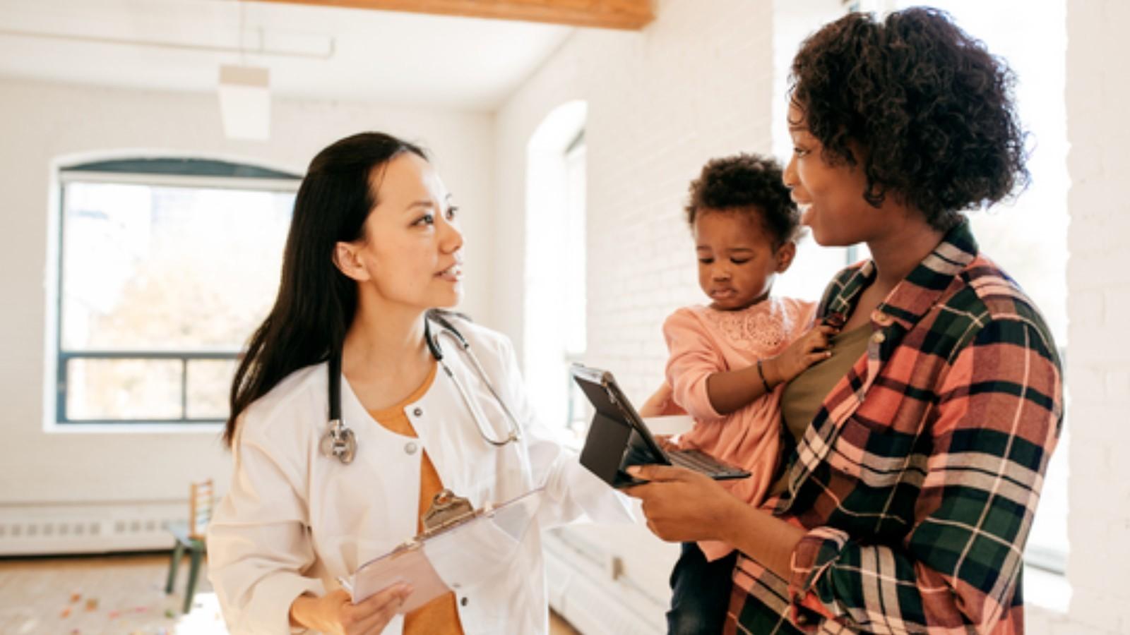 mother holding a child and consulting a doctor