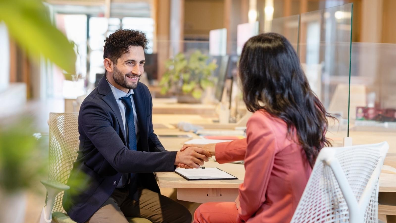 Male entrepreneur shaking hand with female professional