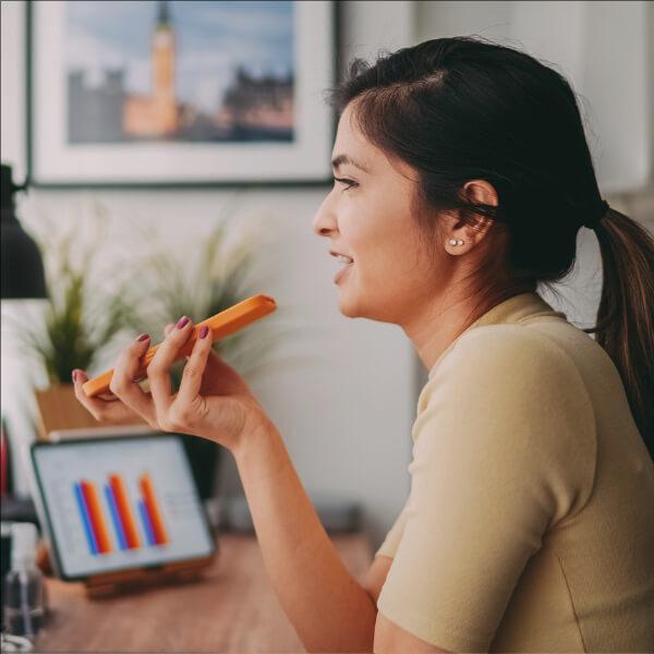 Woman looking at data on screen and talking over phone.