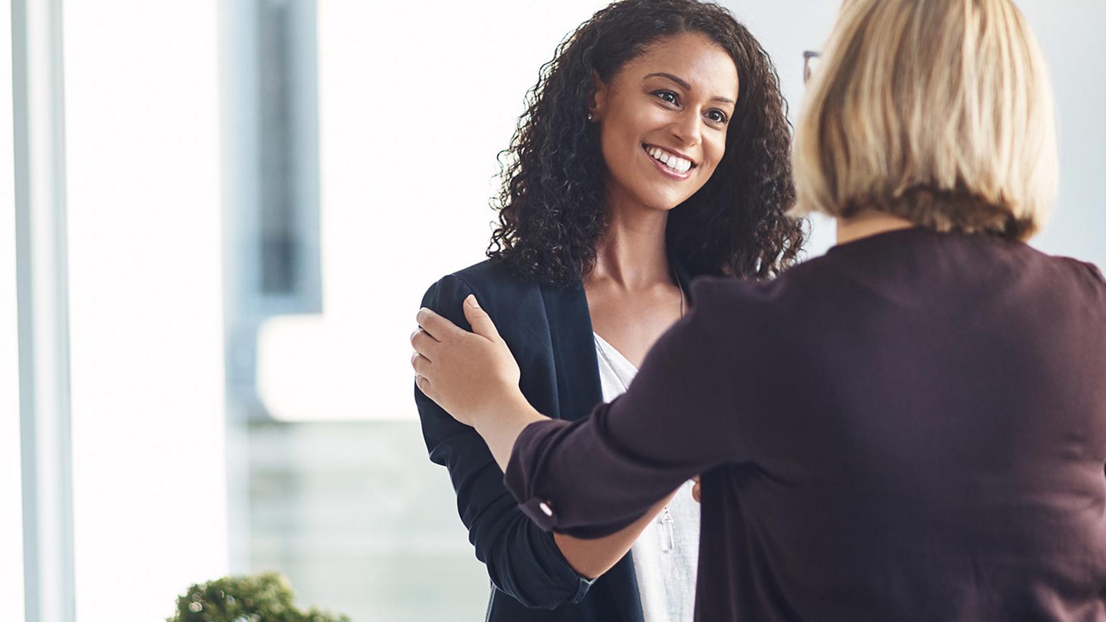 2 women shaking hands in the office