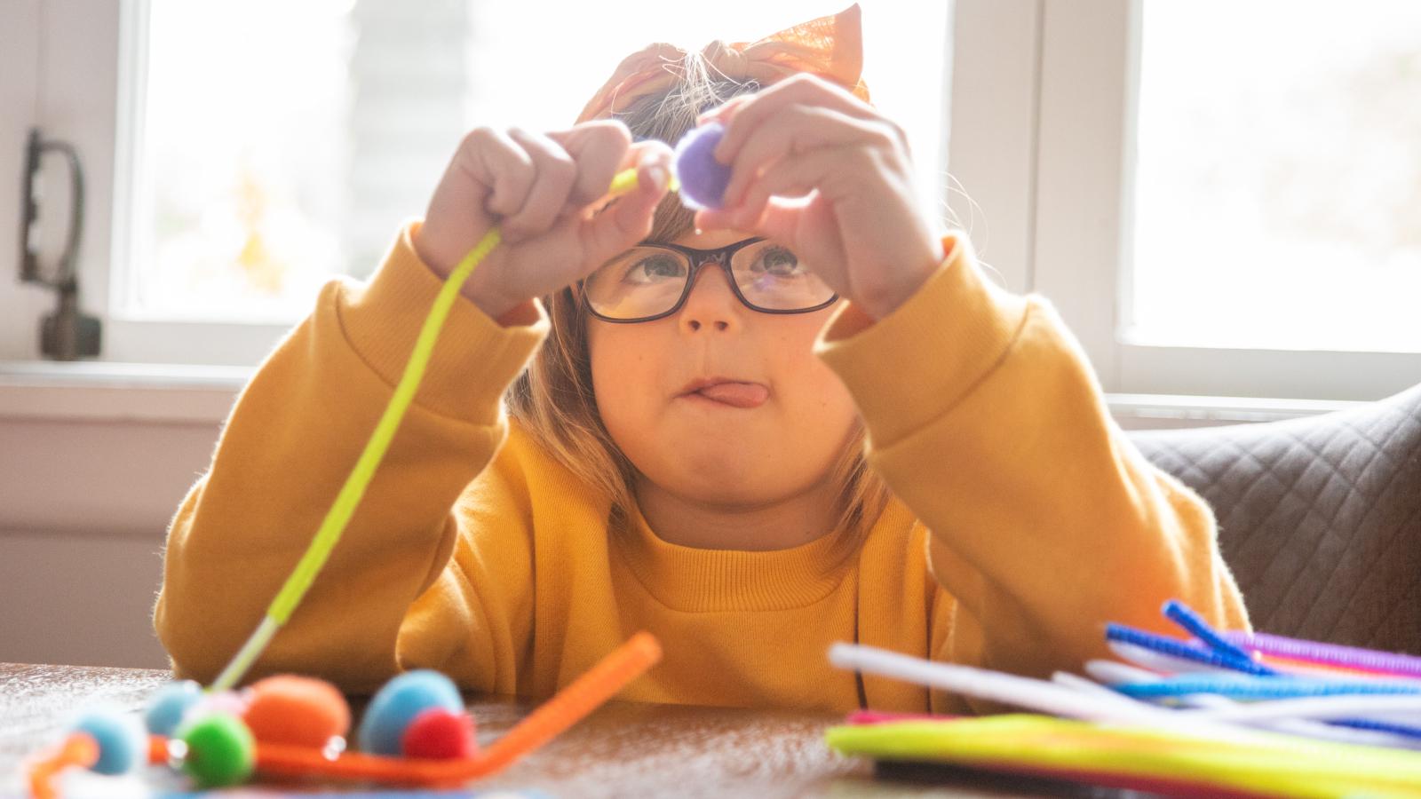 Child with autism sitting at table doing craft