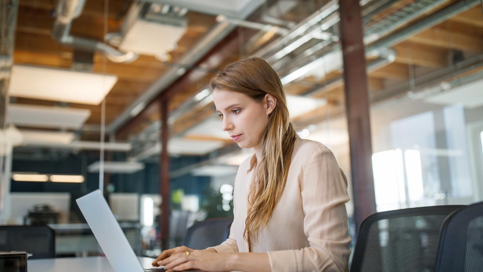 Young businesswoman using laptop in office