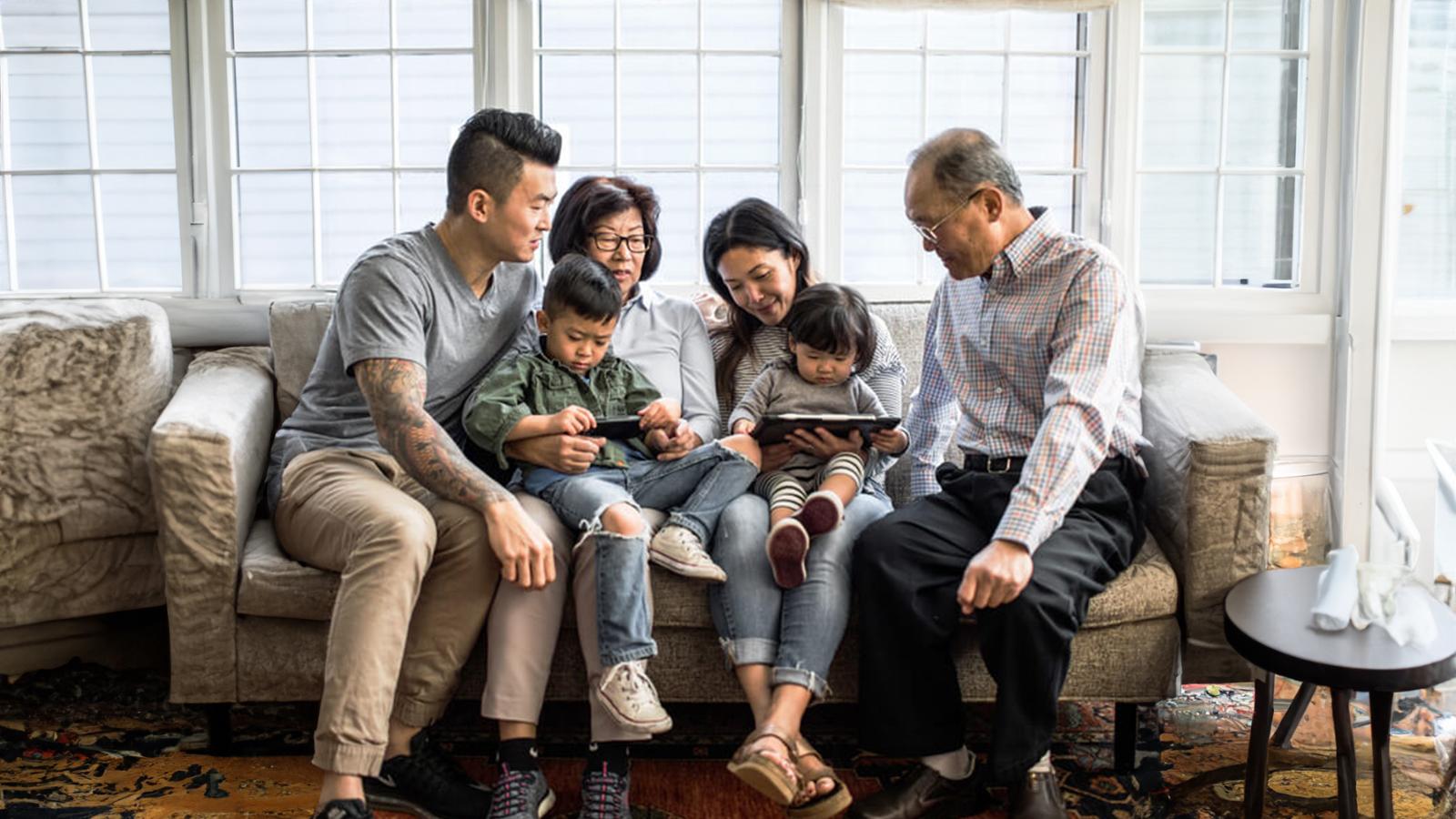 Large chinese family sitting on the couch.
